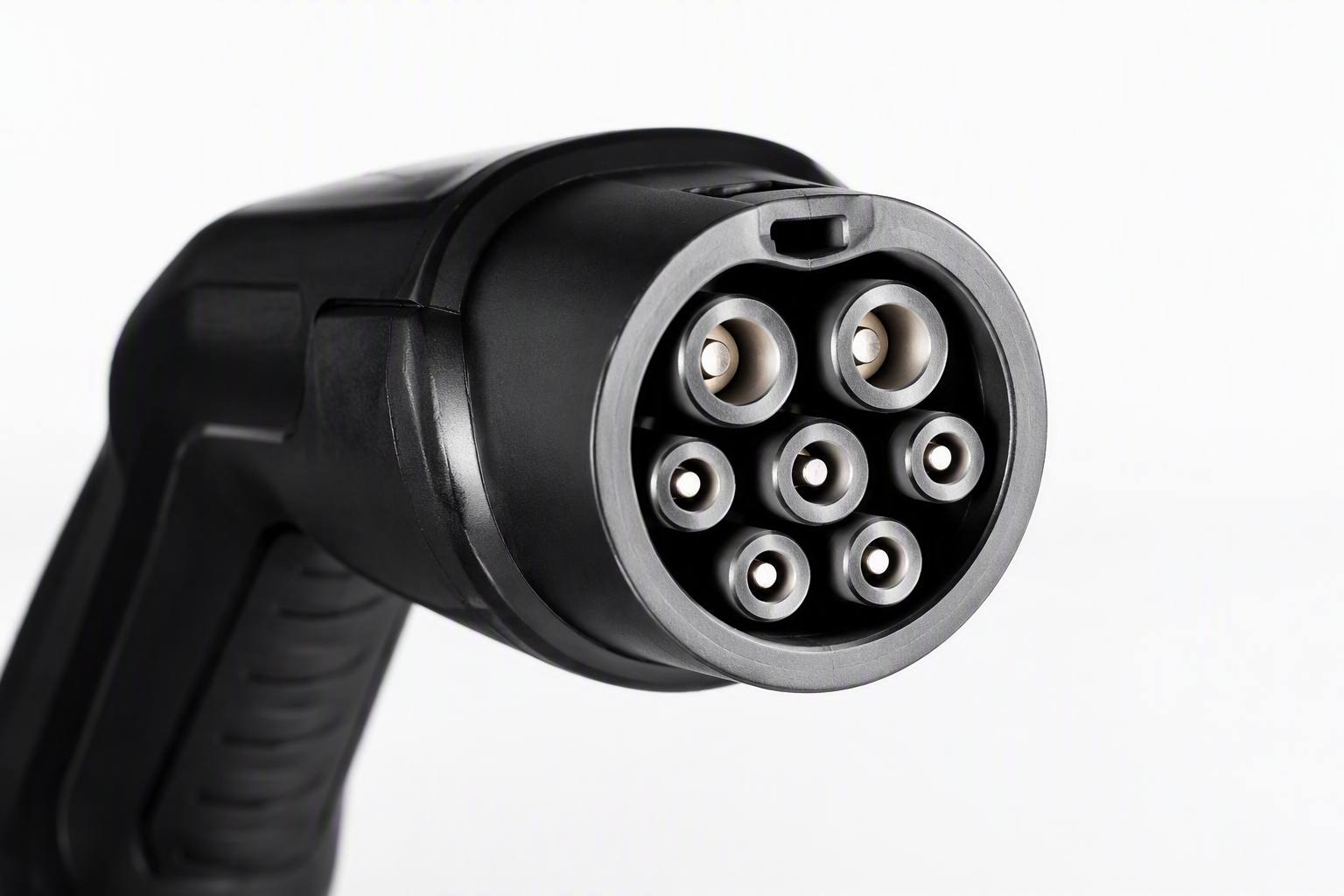 Close-up of a Type 2 IEC 62196-2 AC charging connector, seven-pin round metal contacts, white background product photography