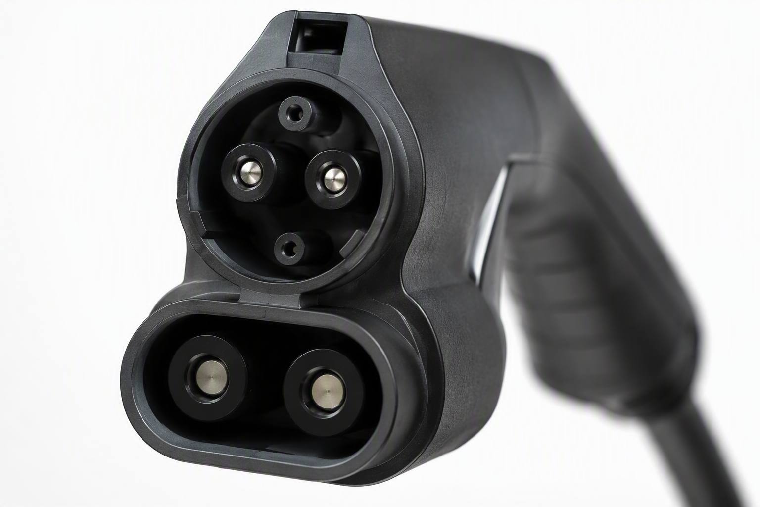 Close-up of a CCS2 combined DC fast charging connector, large black handle with two high-current power pins, white background product photography