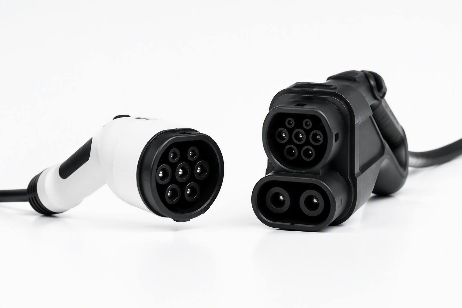 Two EV charging connectors side by side for comparison: Type 2 AC connector on the left labeled A, CCS2 DC fast charging connector on the right labeled B, white background product photography